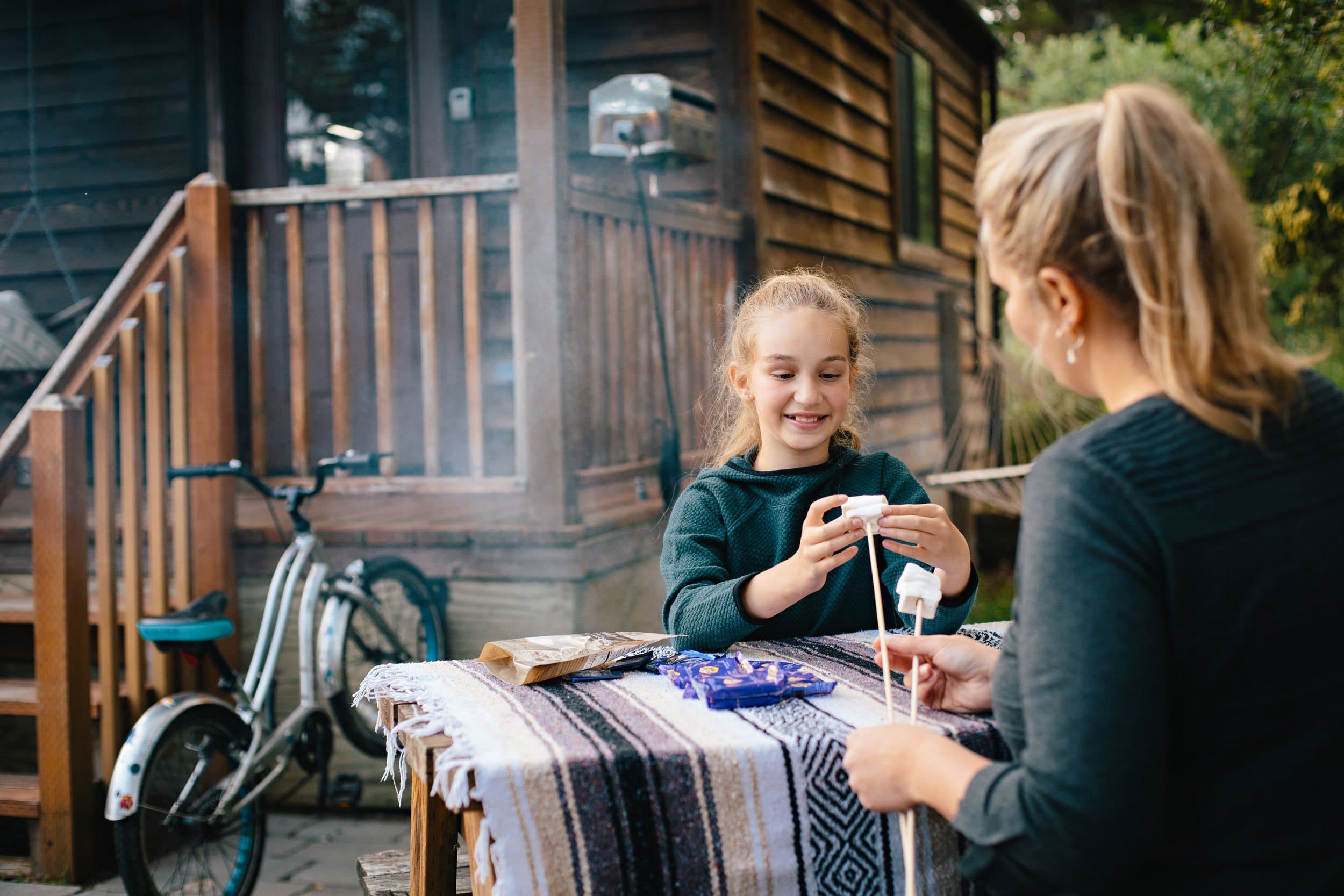 A mother and daughter making smores at Hart's Camp