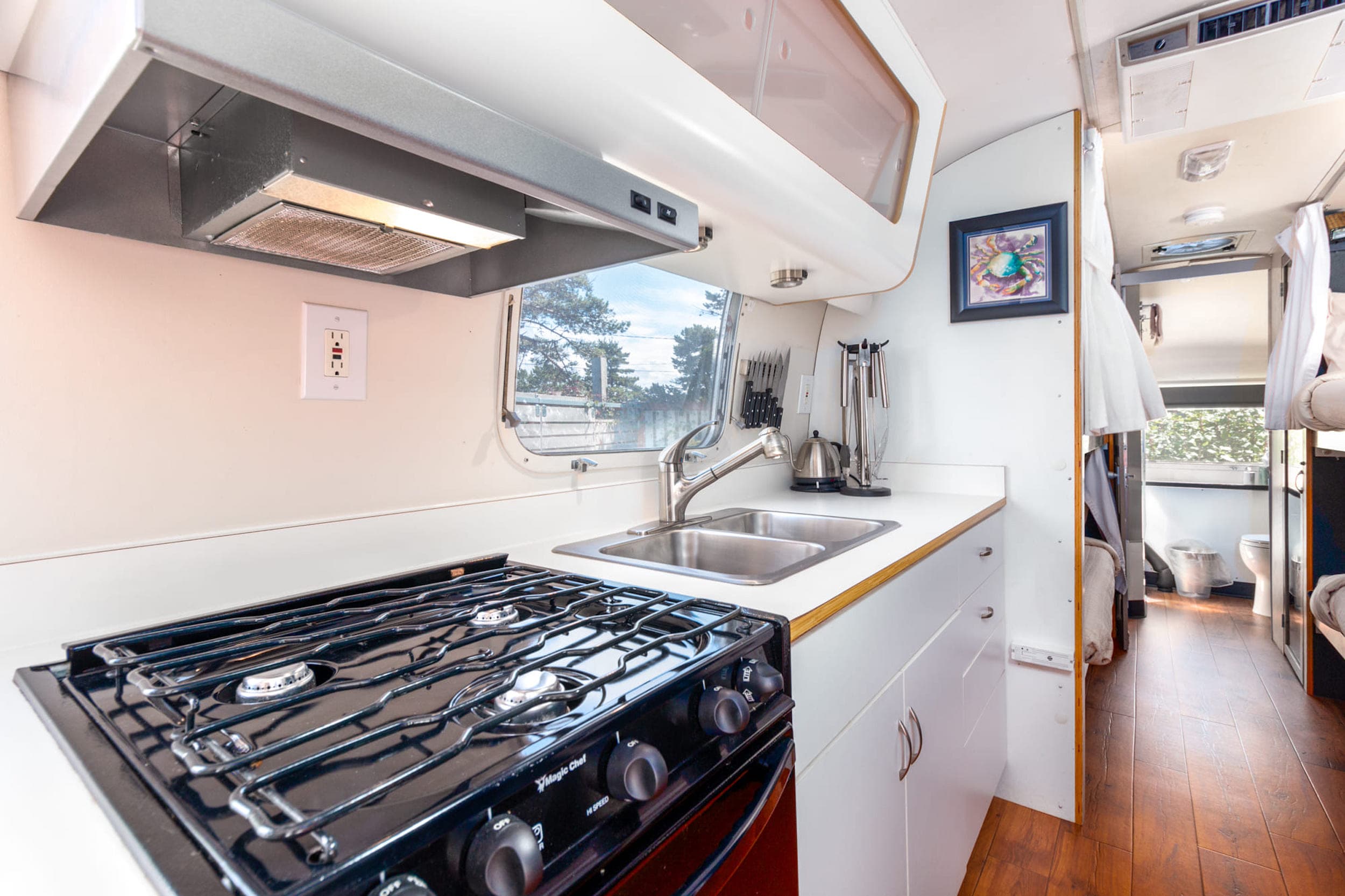 The stove top and sink in a kitchen of the bunk airstream at Harts Camp