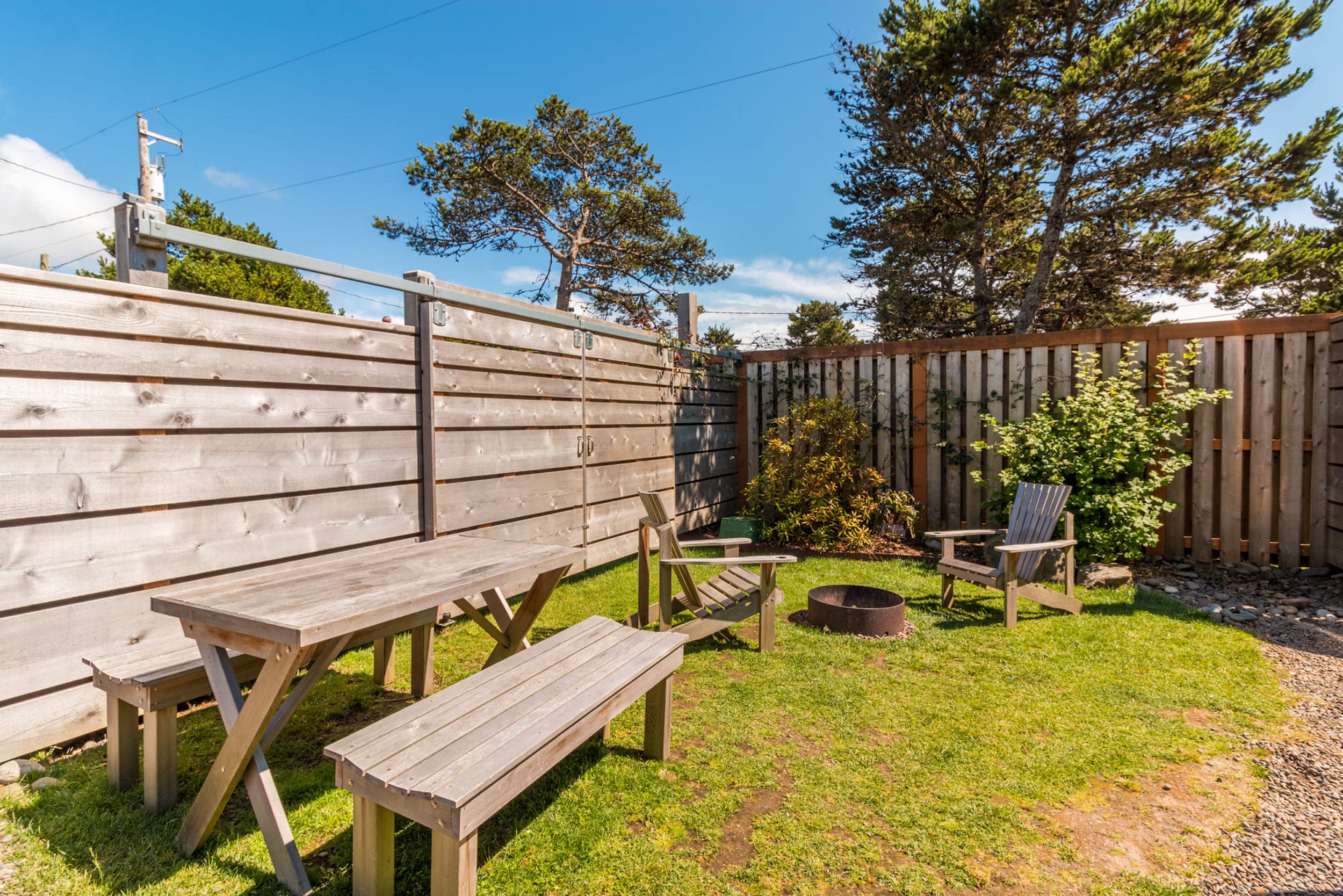 A picnic table and fire pit outside a bunk airstream at Harts Camp
