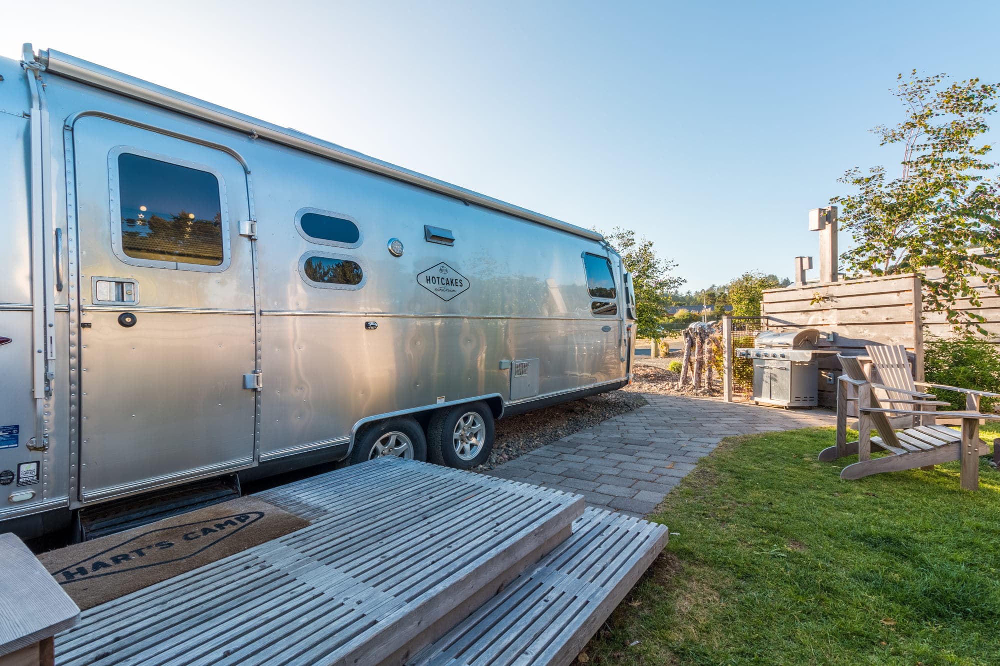 The exterior of a Premium Airstreams at Harts Camp with a fire pit and deck