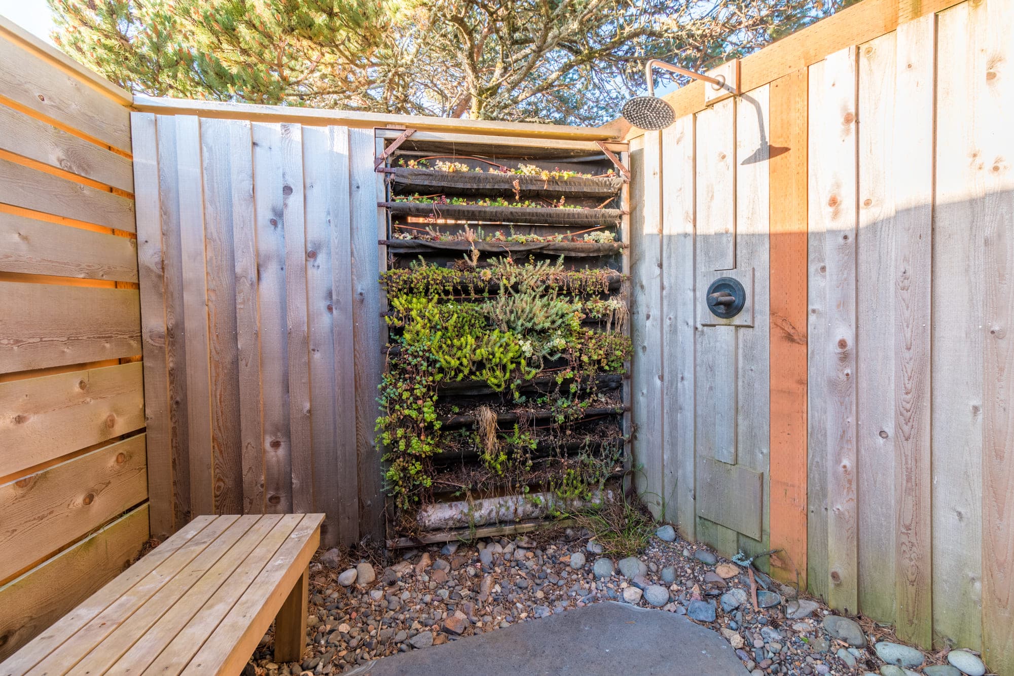 An outdoor shower area of a standard airstream with a living wall