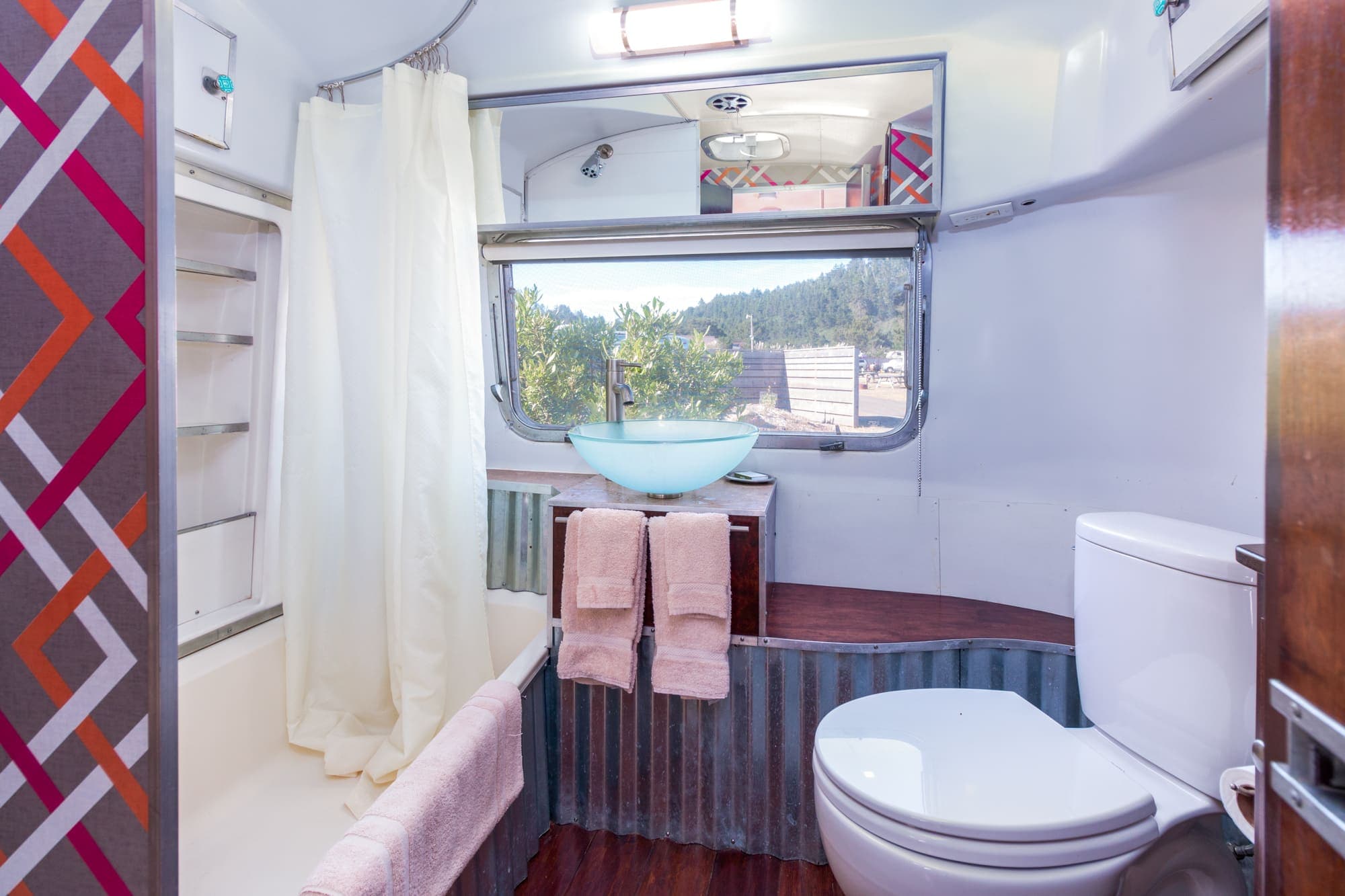 The bathroom with a tub, vanity, and toilet in a vintage airstream at Harts Camp
