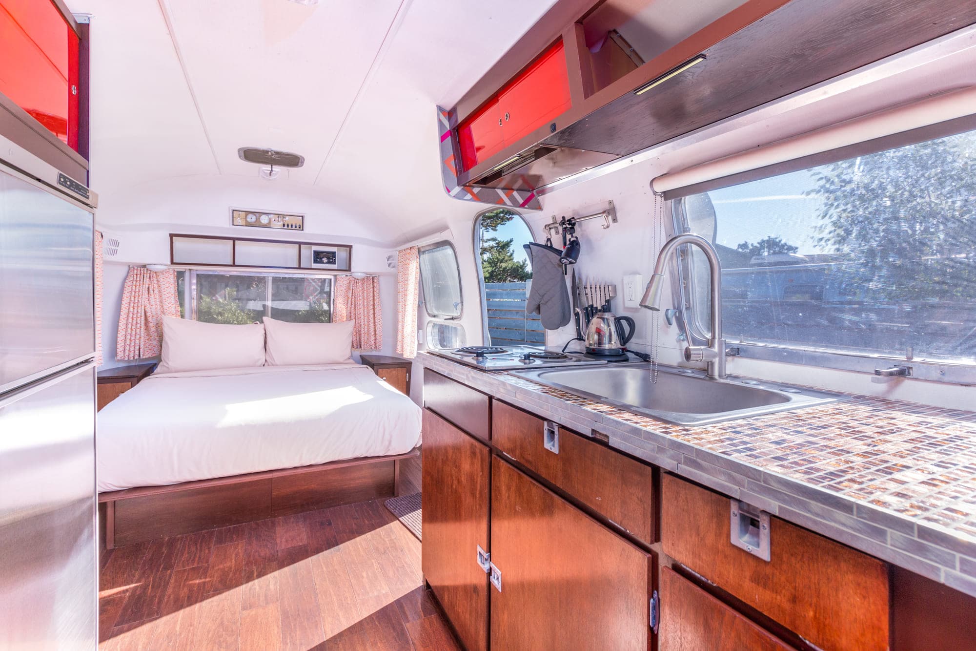 The kitchen sink area and bedroom in a vintage airstream at Harts Camp
