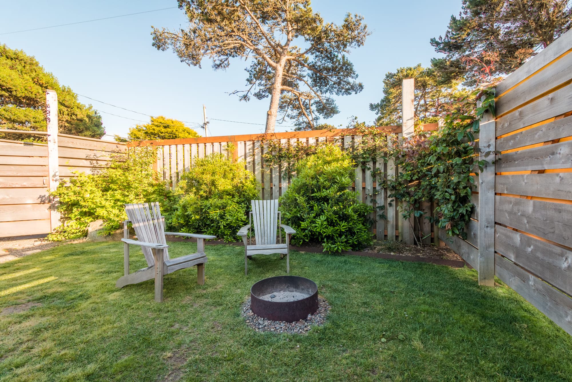 A grassy fire pit area outside a vintage airstream at Harts camp