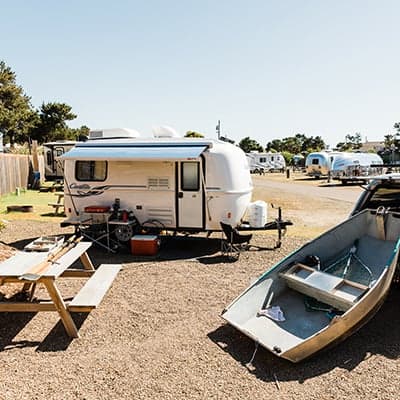 A camper on the RV site at Hart's Camp with a picnic table, camping stove setup, and a boat