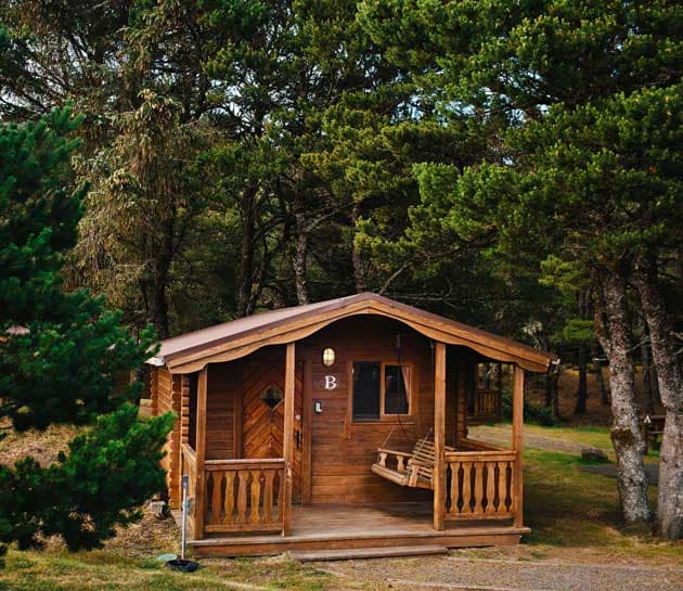 The exterior of a cabin surrounded by trees at Harts Camp