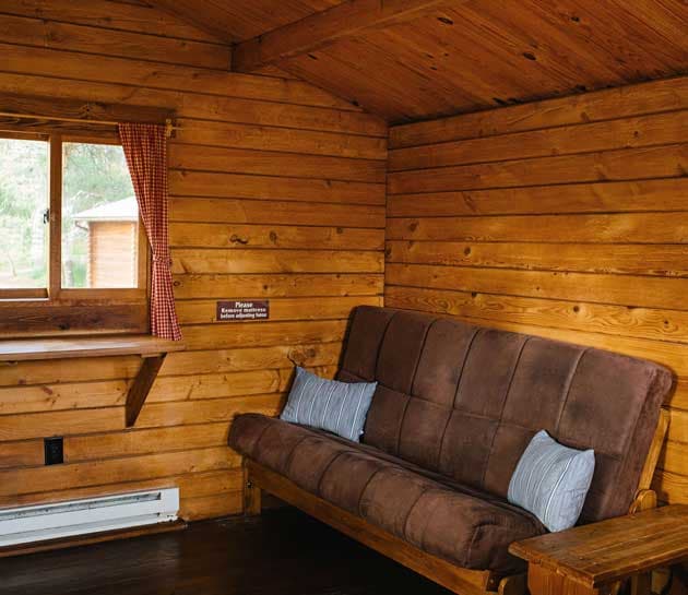 The wooden futon couch inside a cabin at Harts Camp