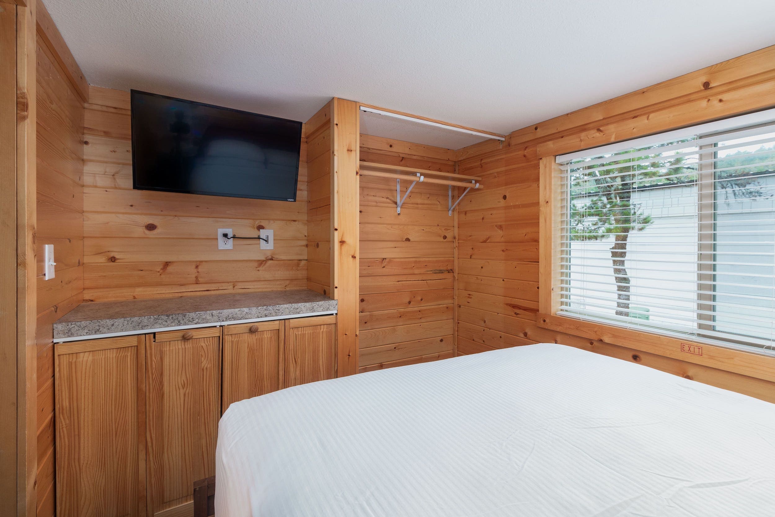 A bedroom with television and closet at Hart's Camp, Pacific City, OR