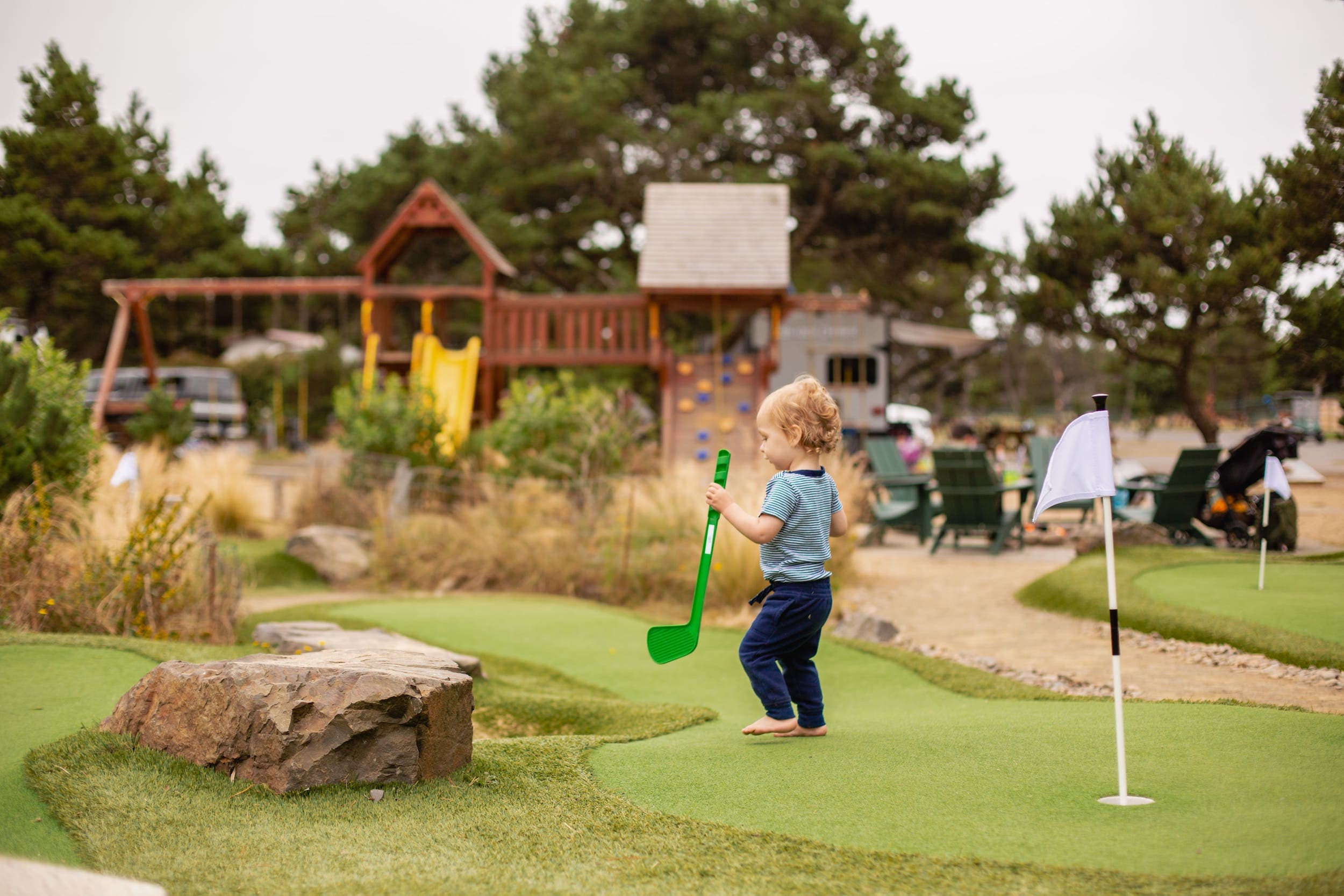 A child with a mini golf club playing mini golf at Harts Camp