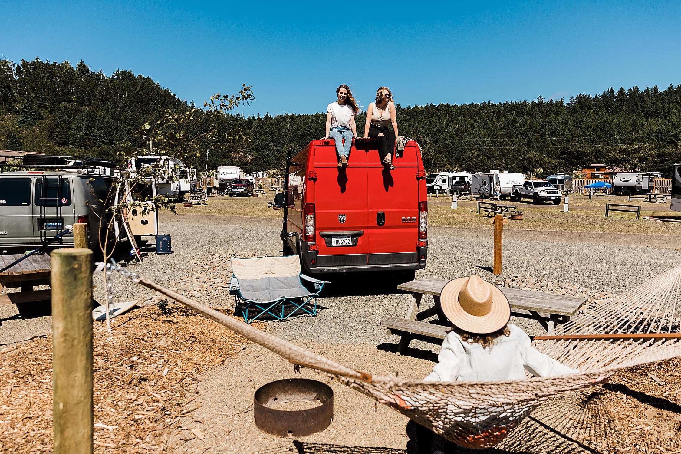 Friends hanging out on a camper van and hammock at The Inn at Hart's Camp RV park in Pacific City on the Oregon Coast.