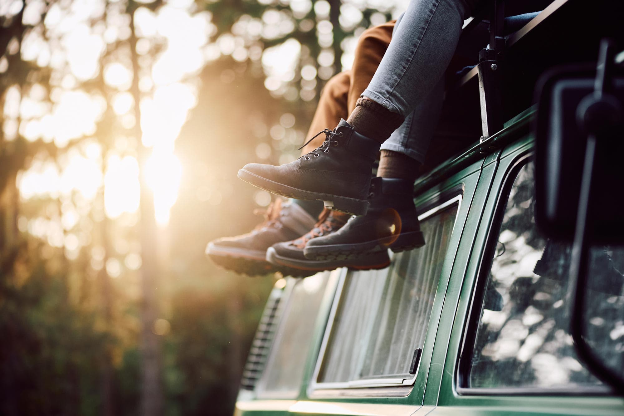 two people sitting on top of a van