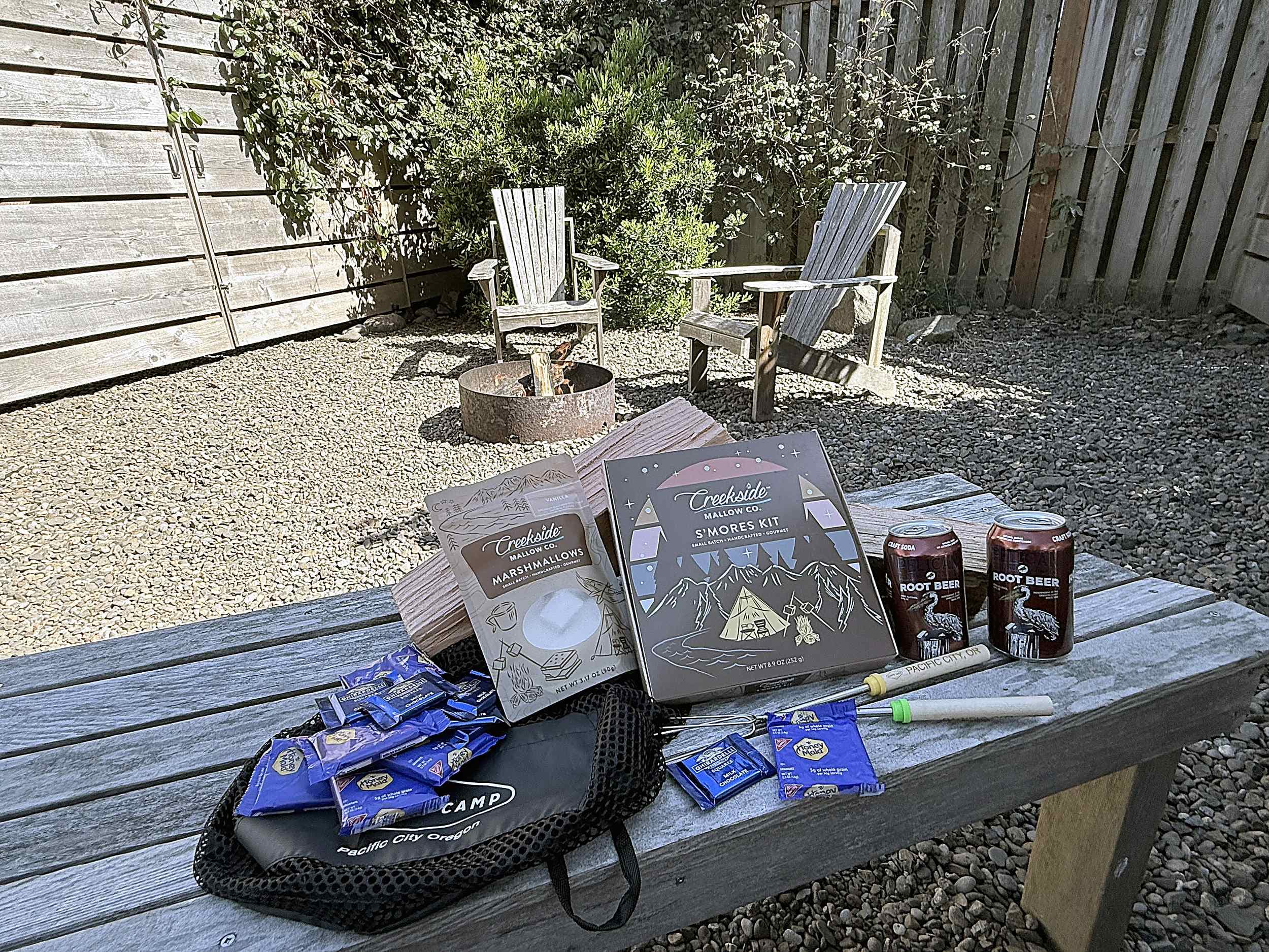 S'mores kit with roasting sticks and root beer beside a glowing fire pit at The Inn at Hart's Camp near Haystack Rock, Oregon Coast