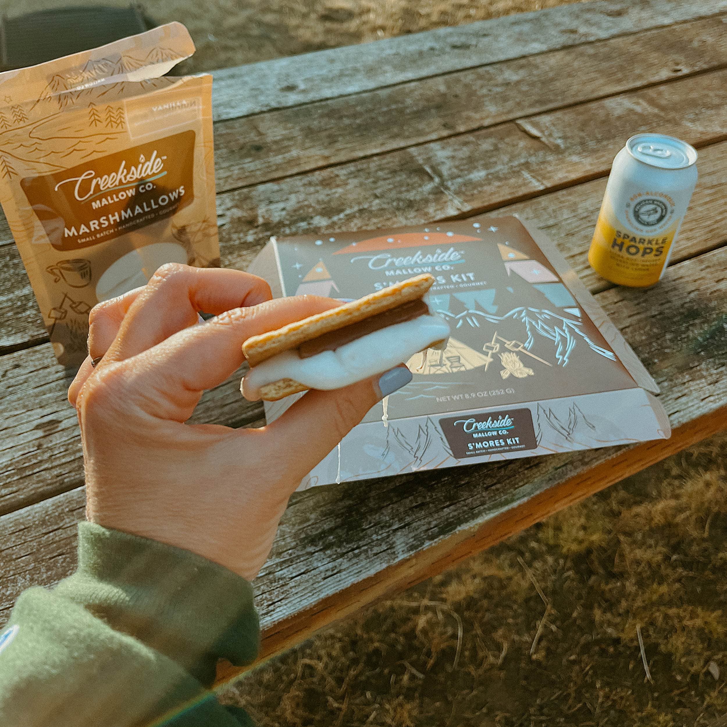 Guest holding a freshly made gourmet s'more from the Creekside Mallow Co. kit at Hart's Camp, Pacific City