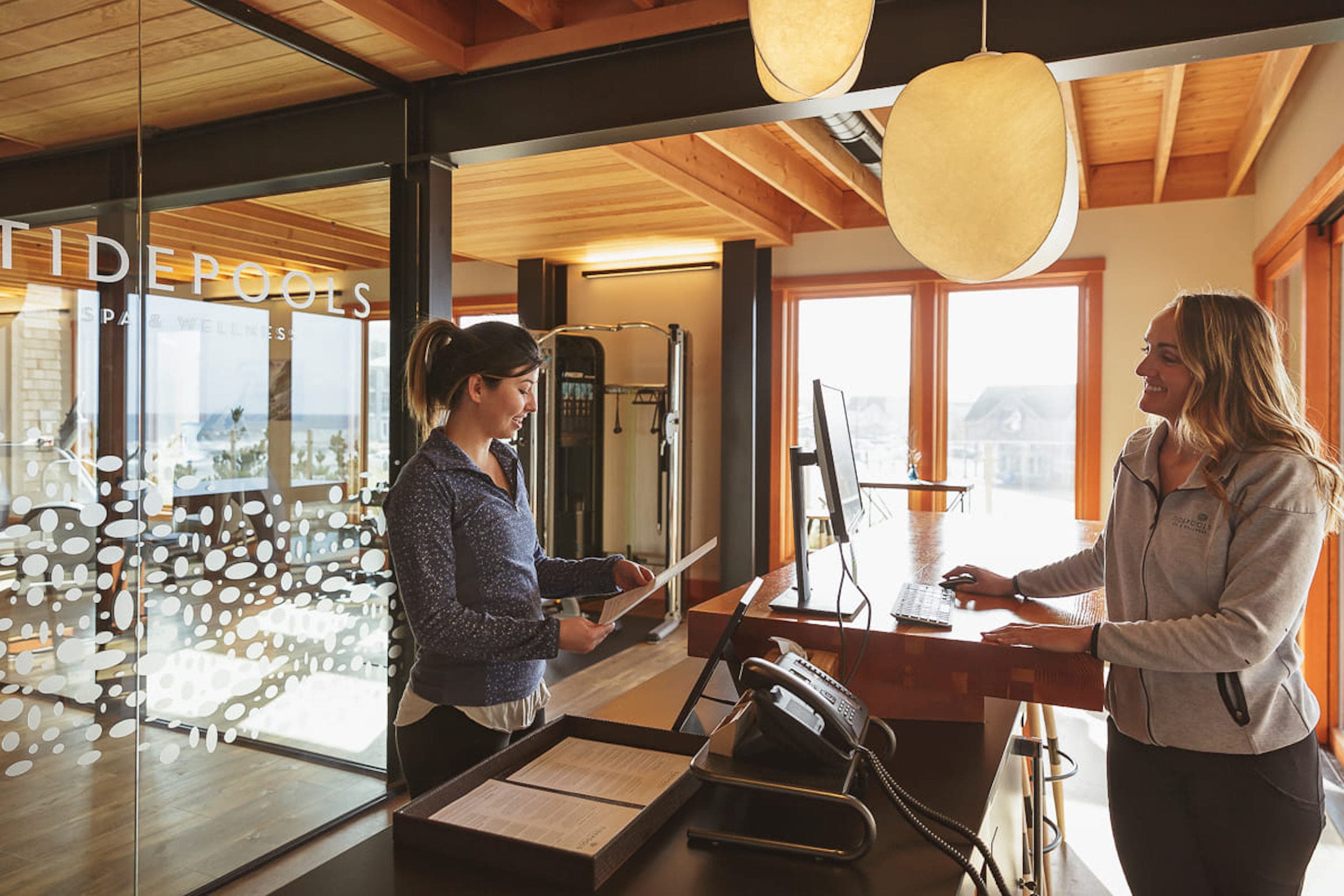 A woman talking to the Spa service counter woman at Tidepools Spa