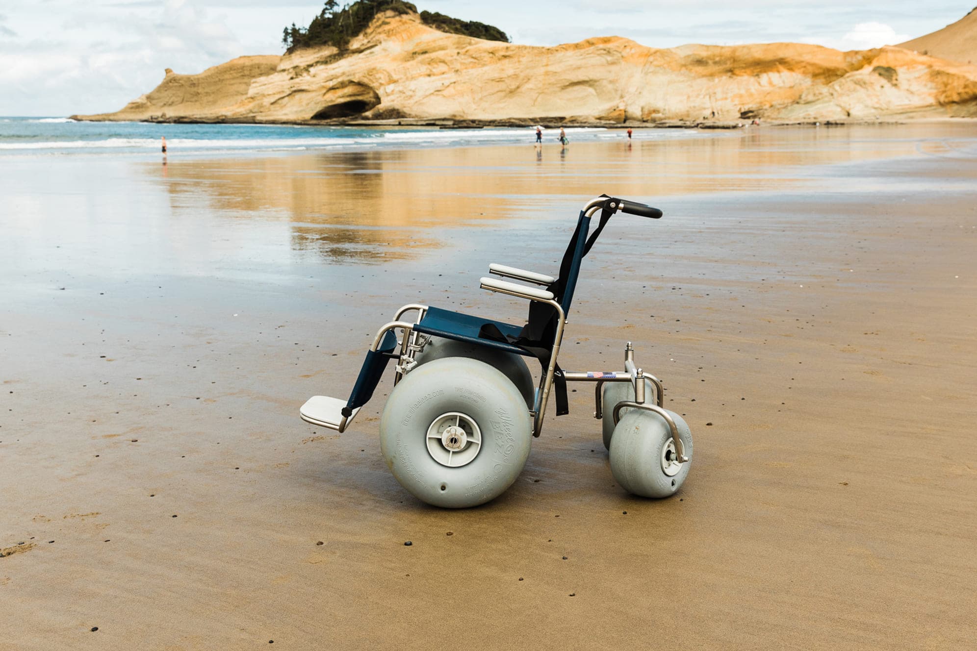 A wheelchair with large wheels on the beach at Hart's Camp