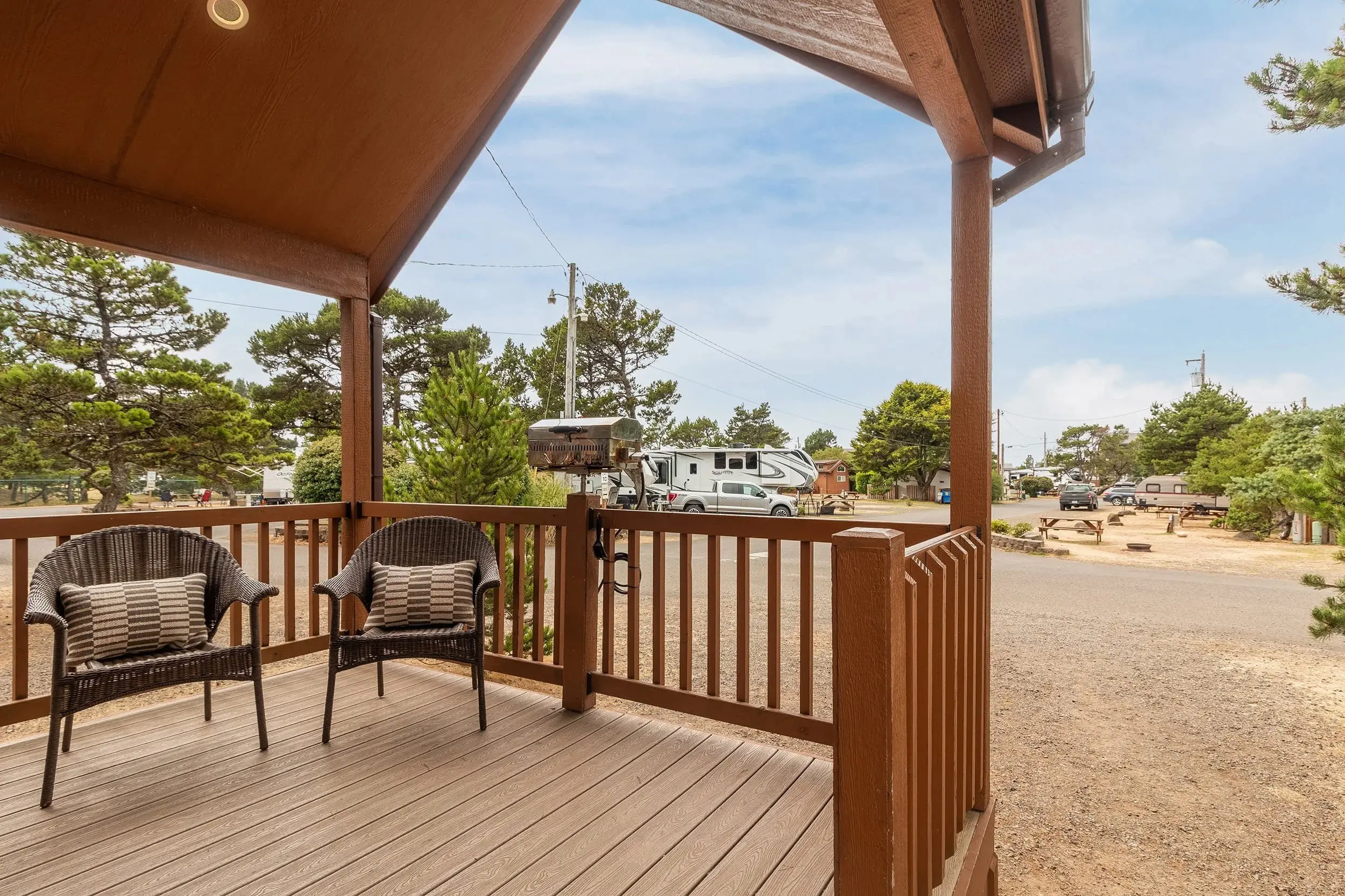 A deck of a cottage with a view of an RV at Hart's Camp