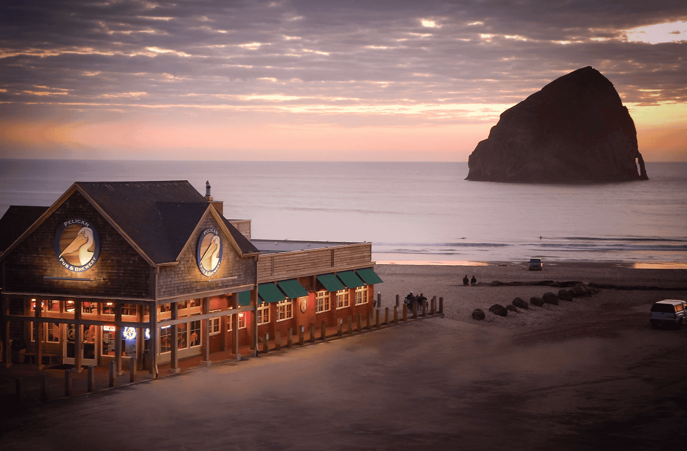 Pelican Pacific City Exterior at sunset with a beautiful pink sky and calm ocean waters
