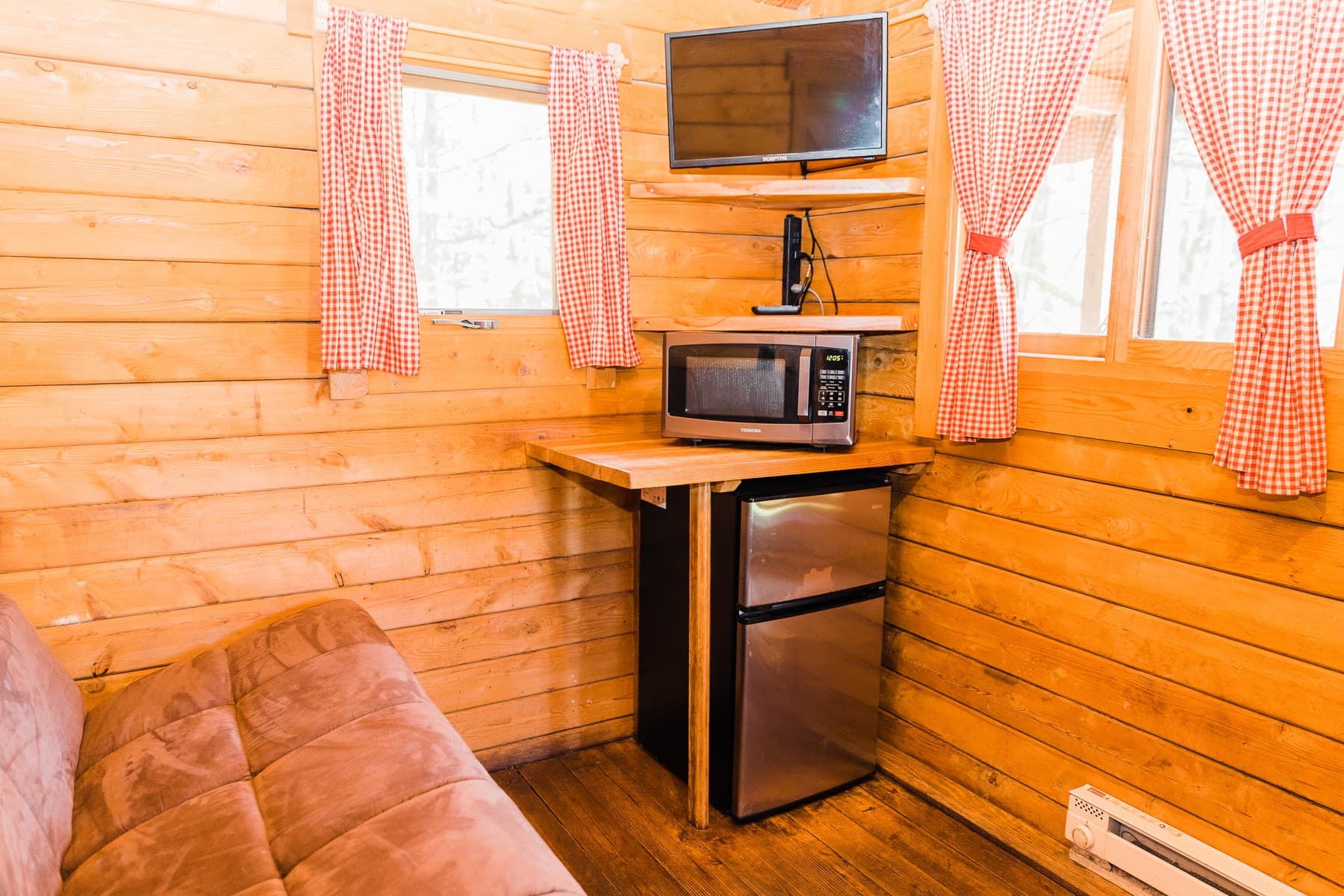 Microwave, mini fridge and TV in a rustic cabin at the Pacific City, Oregon glamping resort near Cape Kiwanda