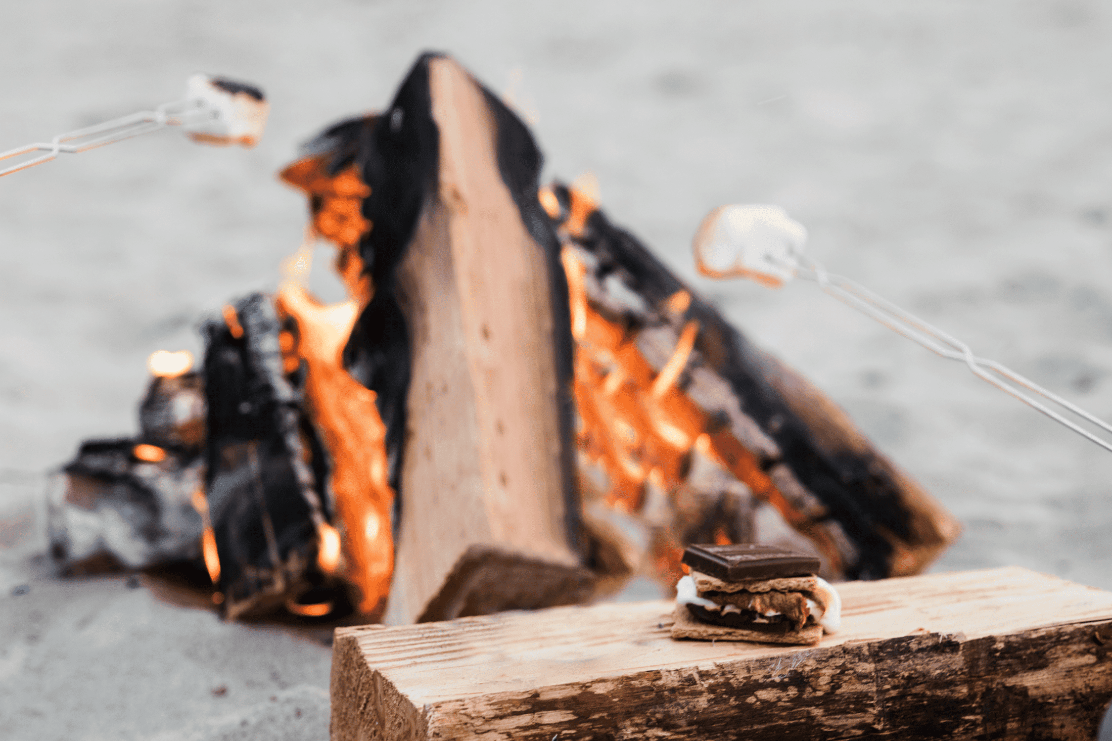 A close up of a smore beside a fire pit at Hart's Camp