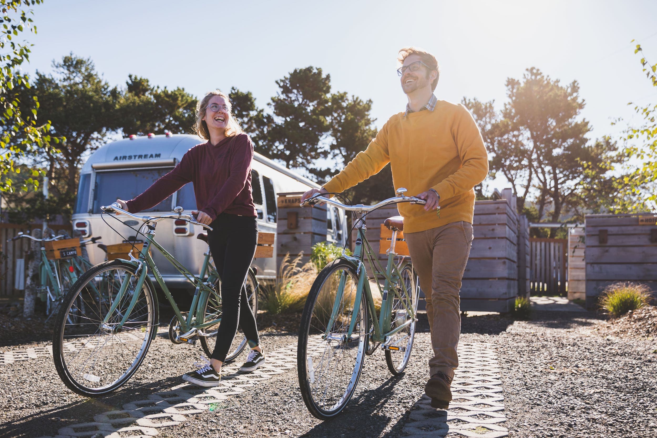 A couple leaving an airstream at harts Camp walk bikes they rented