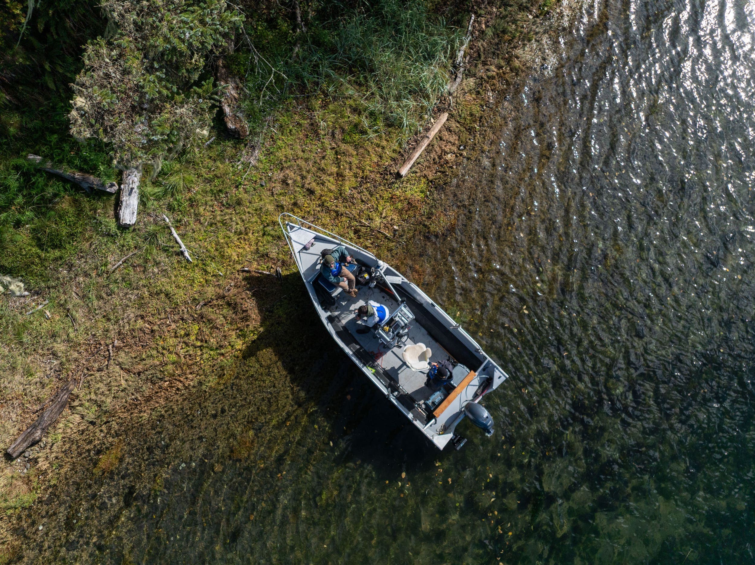 An overhead view of people in a fishing boat fishing off the shore near Harts Camp