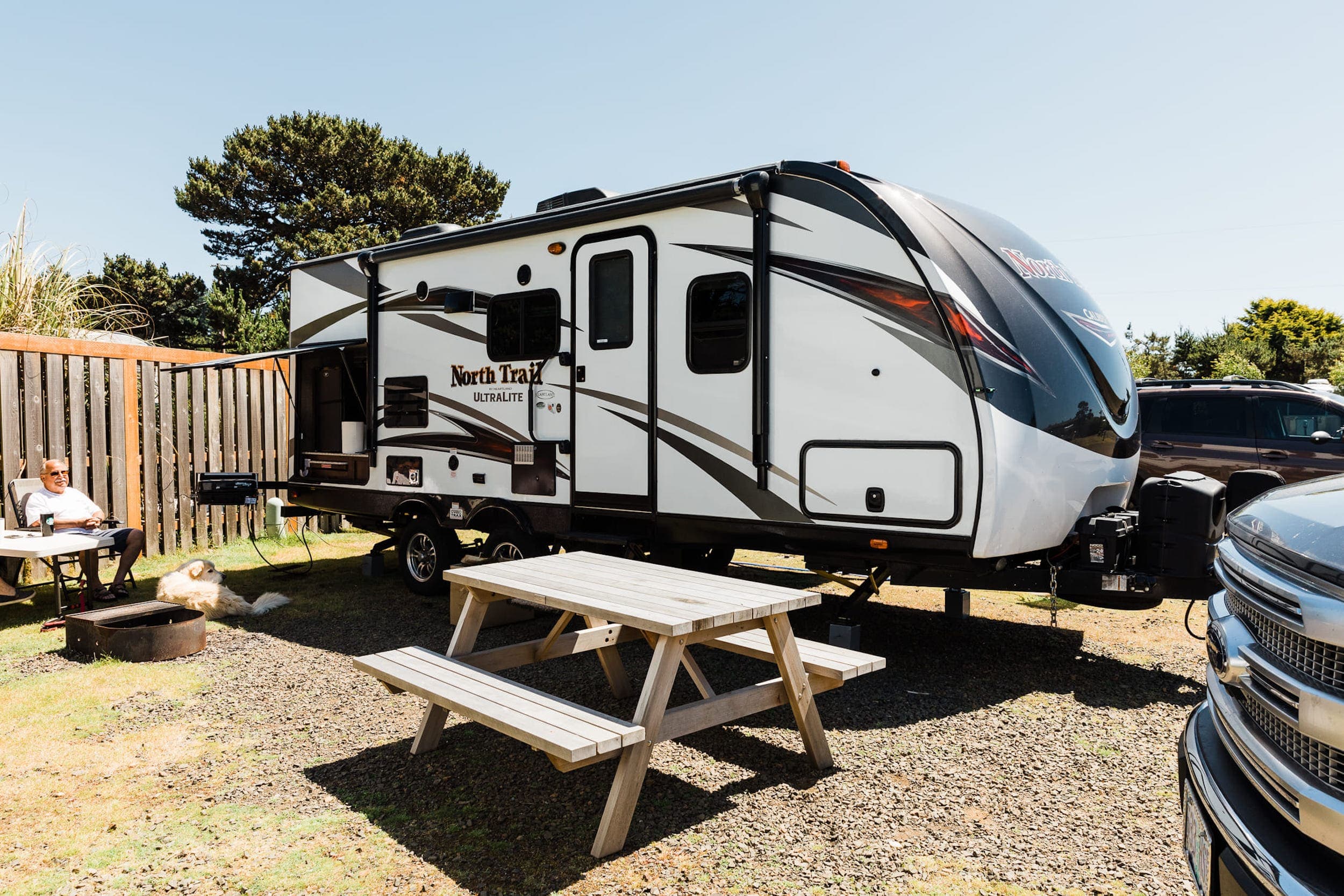 A man and his dog enjoying an RV site at Harts Camp, Pacific City