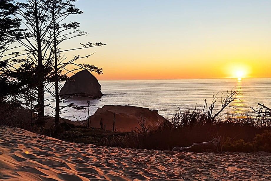 Sunset view of Haystack Rock from the Cape Kiwanda dunes, a sightseeing highlight near The Inn at Hart's Camp in Pacific City, Oregon.